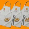 Три серых фартука с ДТФ-печатью FLOUR & OAT, расположены внахлёст под углом три четверти