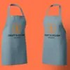 Два серо-голубых фартука Craft & Dough с логотипом на груди, развёрнуты вполоборота друг к другу