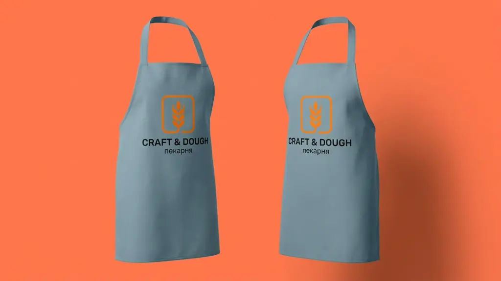 Два серо-голубых фартука Craft & Dough с логотипом на груди, развёрнуты вполоборота друг к другу