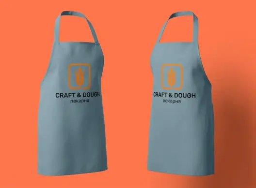 Два серо-голубых фартука Craft & Dough с логотипом на груди, развёрнуты вполоборота друг к другу