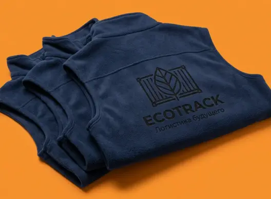 Три тёмно-синих флисовых жилета EcoTrack, сложенных с углом три четверти — виден брендированный принт на спинке верхнего