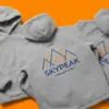 Три куртки-шерпа SkyPeak на оранжевом фоне — объёмные капюшоны и фактура флиса