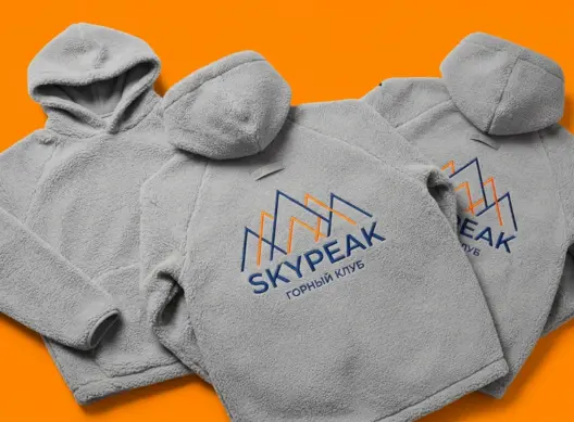 Три куртки-шерпа SkyPeak на оранжевом фоне — объёмные капюшоны и фактура флиса