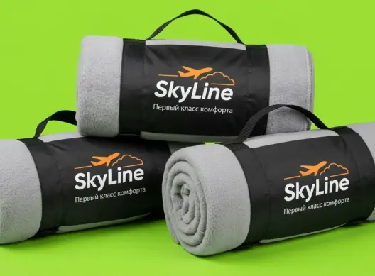 Три пледа SkyLine в чёрных чехлах-переносках, сложенные пирамидой на салатовом фоне