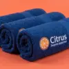 Три тёмно-синих полотенца в рулонах с вышитым логотипом Citrus на переднем плане