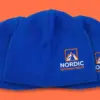 Три синие шапки бини Nordic Peak с вышивкой, уложены внахлёст, ракурс три четверти