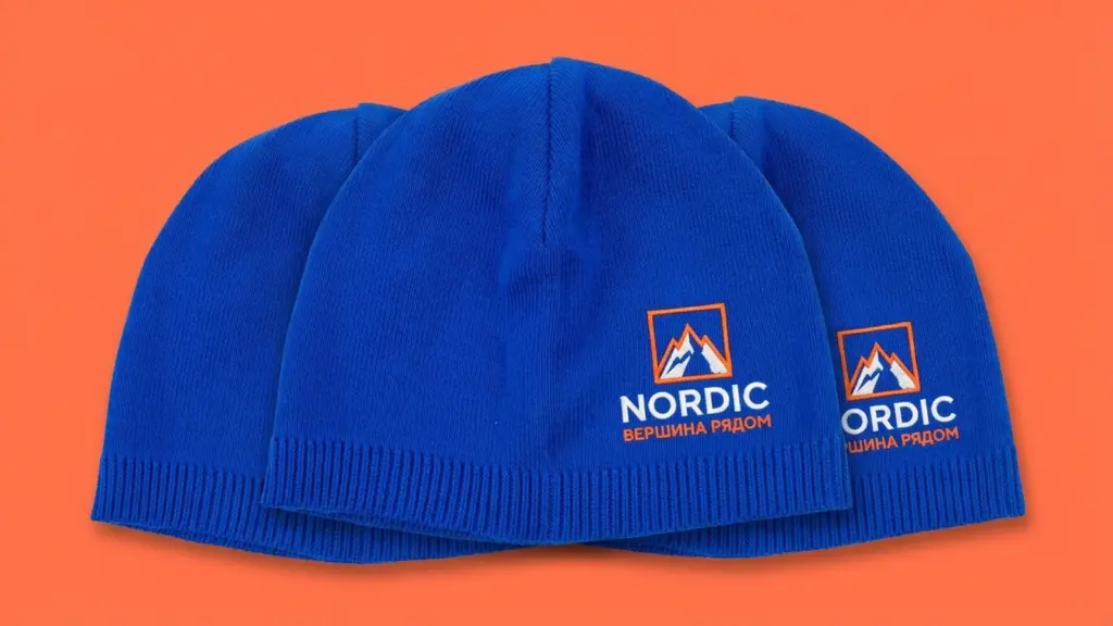 Три синие шапки бини Nordic Peak с вышивкой, уложены внахлёст, ракурс три четверти