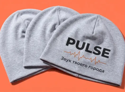 Три шапки-бини PULSE веером на коралловом фоне — видны объём и логотип на передней