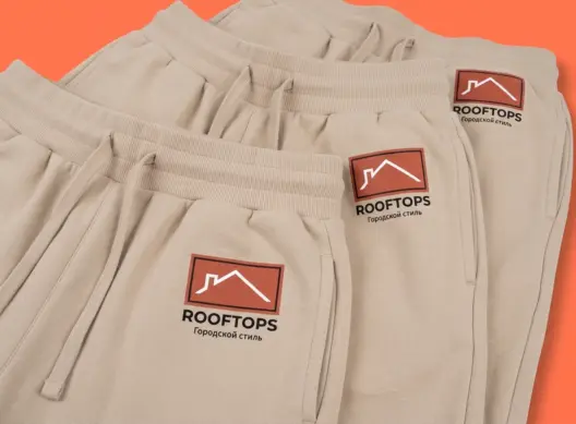 Бежевые шорты ROOFTOPS стопкой в три четверти — виден логотип на бедре