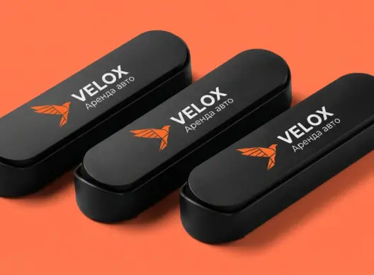 Три парковочные визитки Velox веером — оранжевый логотип сокола на чёрном матовом пластике