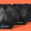 Три чёрных складных зонта SkyGuard Solutions каскадом в ракурсе три четверти на коралловом фоне