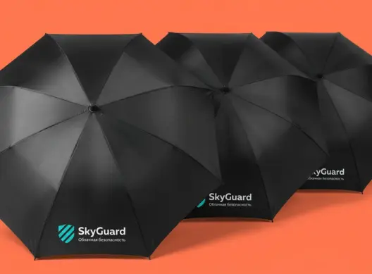 Три чёрных складных зонта SkyGuard Solutions каскадом в ракурсе три четверти на коралловом фоне