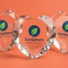 Три стеклянные стелы EcoSphere Tech в форме сердца на коралловом фоне с игрой световых преломлений