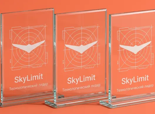 Три стеклянные стелы SkyLimit в ракурсе три четверти — свет преломляется сквозь прозрачные грани