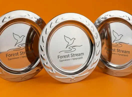 Три хромированные тарелки Forest Stream на оранжевом фоне — динамичная студийная композиция