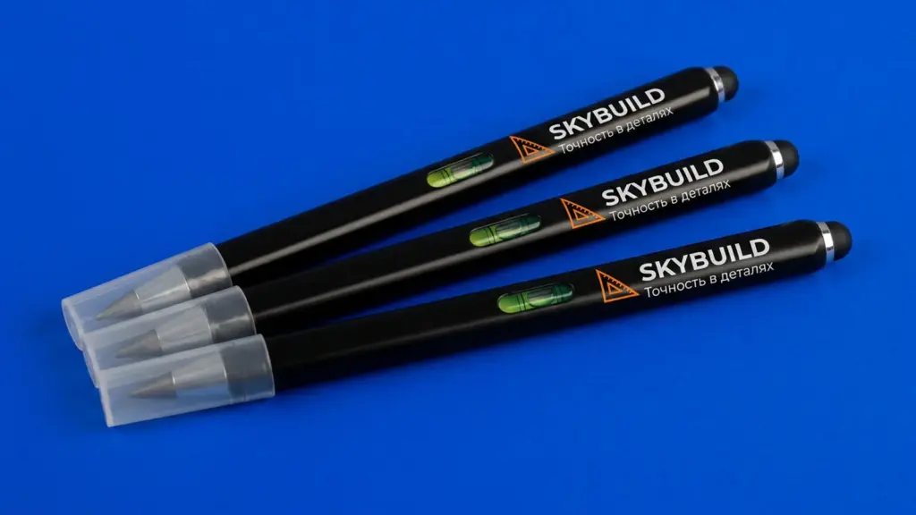 Три вечных карандаша SKYBUILD веером на синем фоне — видна брендированная зона и встроенный уровень